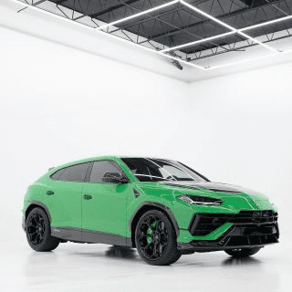 Bright green sport SUV with black wheels and a black roof parked in a white studio with bright overhead lights
